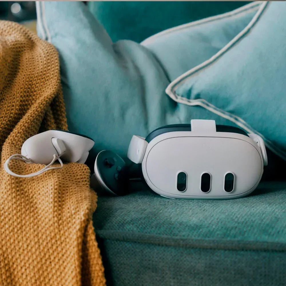 Virtual reality headset and controllers on teal sofa with mustard yellow blanket