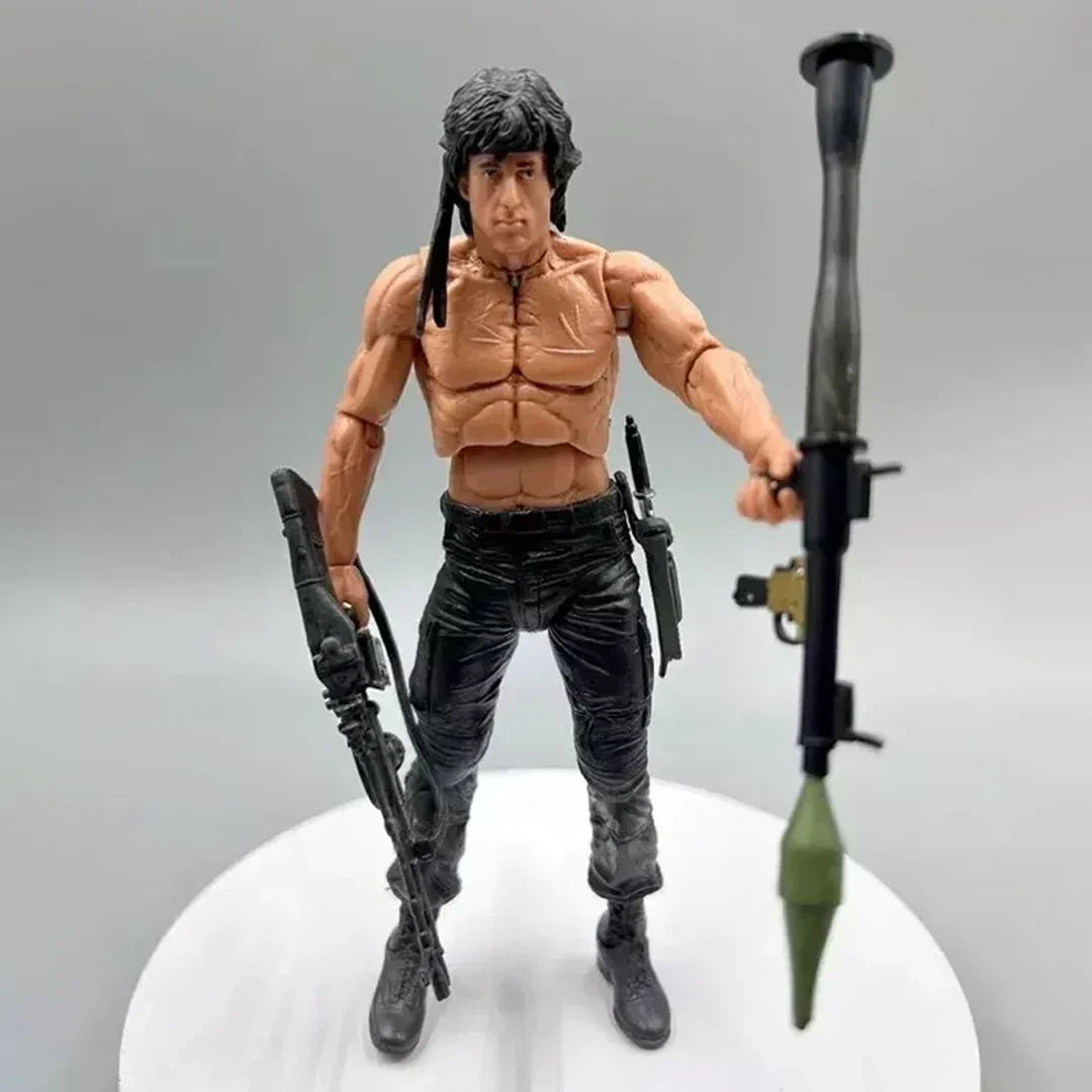 Muscular action figure with black pants holding a rifle and rocket launcher, collectible toy