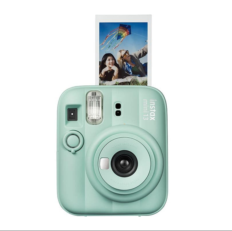 Mint green instant camera with a photo attached on a white background