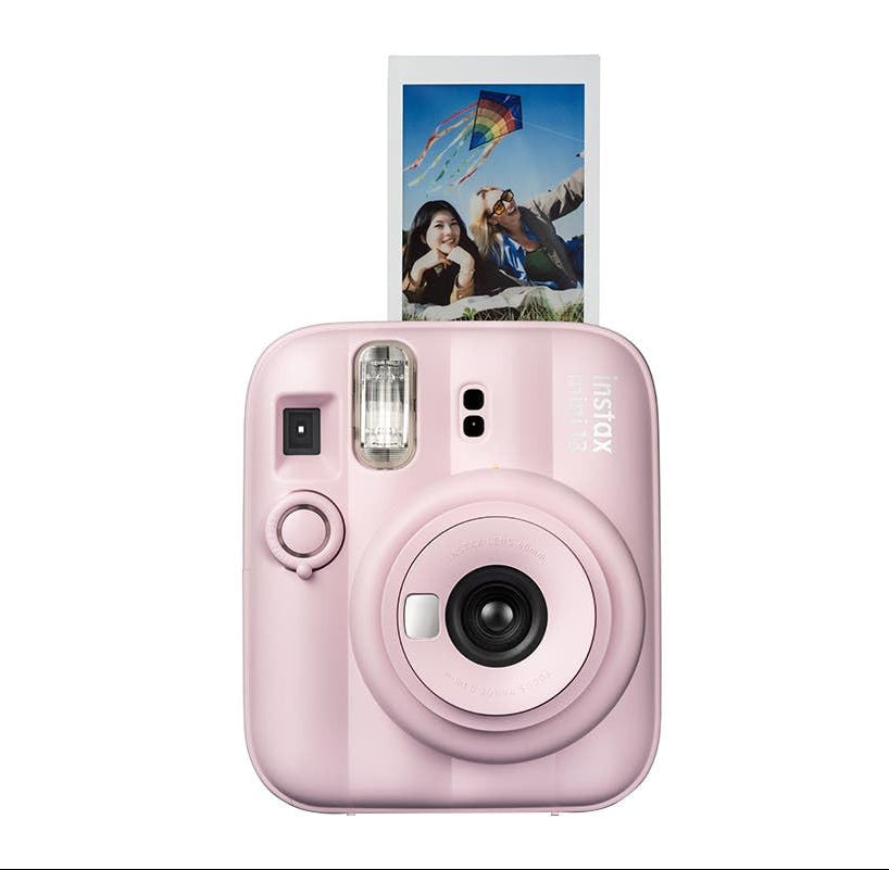 A pink Fujifilm Instax Mini Evo instant camera with a printed photo slide coming out of the top, shown against a solid white background.