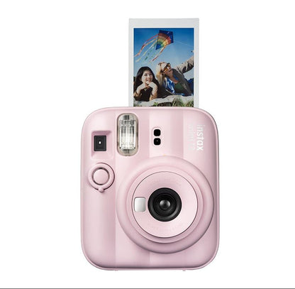 A pink Fujifilm Instax Mini Evo instant camera with a printed photo slide coming out of the top, shown against a solid white background.
