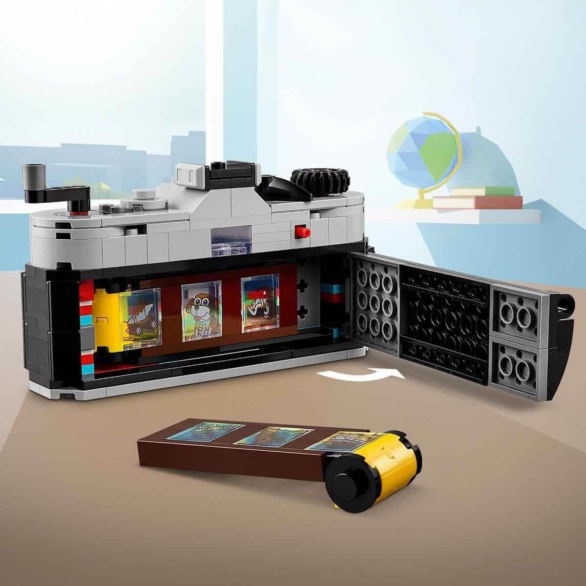 LEGO camera toy with open back showing film roll and mini photo slides on a tabletop
